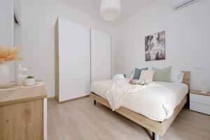 a bedroom with a large bed with white sheets at Elegante e Comodo - A pochi minuti dall'Aeroporto in Fiumicino