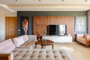 ein Wohnzimmer mit Sofa und Fernseher in der Unterkunft Appartement de Luxe - Piscine et Accès à la Plage in Bouznika