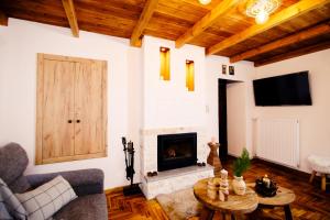 a living room with a fireplace and a wooden ceiling at Oiti Mountain Apartments in Pavliani