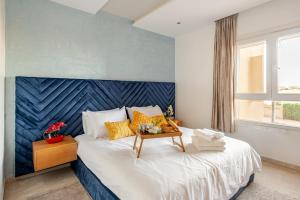 ein Schlafzimmer mit einem großen Bett mit blauem Kopfteil in der Unterkunft Appartement de Luxe - Piscine et Accès à la Plage in Bouznika + 19 Fotos
