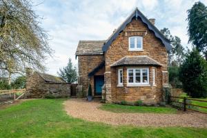una vieja casa de ladrillo con techo de gambrel en Park Cottage, en Glaston