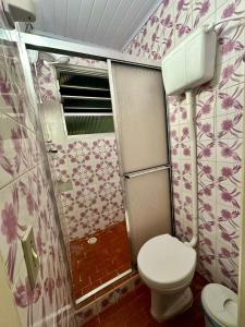 une petite salle de bain avec toilettes et douche dans l'établissement Villa Ruth, a casa que voce vai amar, à Torres