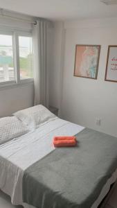 a orange object sitting on a bed in a bedroom at Apartamento Beira Mar de João Pessoa PB in João Pessoa