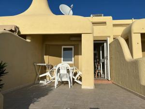 a patio with chairs and a table on a house at Il Paradiso è qui in SantʼAntìoco