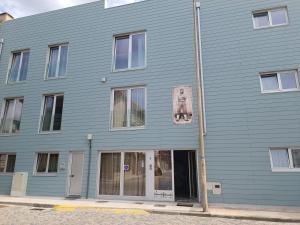 a blue building with a dog on the side of it at Cachinnans Hostel & apartaments in Vila do Conde
