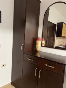 a dresser with a mirror and a brown cabinet at Saranda Spot Apartment in Sarandë
