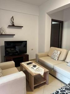 a living room with a couch and a coffee table at Saranda Spot Apartment in Sarandë