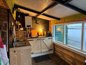 a kitchen with a sink and a window at The Historical Trick Hut in the middle of the Lake in Baambrugse Zuwe