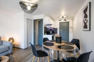 un salon avec une table et des chaises dans l'établissement Panoramique balcon wifi centre-ville, à Millau 15 autres photos