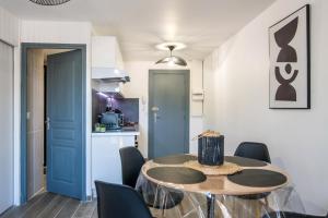 une cuisine et une salle à manger avec une table et des chaises dans l'établissement Panoramique balcon wifi centre-ville, à Millau