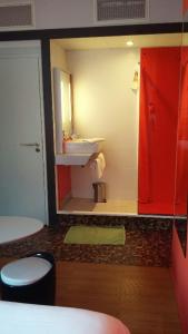 La salle de bains est pourvue d'un lavabo et d'une porte rouge. dans l'établissement ibis Styles Saint Brieuc Gare Centre, à Saint-Brieuc