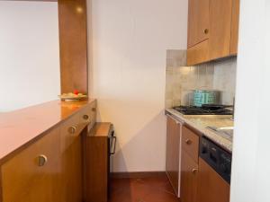 a kitchen with wooden cabinets and a stove top oven at 10 minuti a piedi dal centro - Zona Tranquilla e Silenziosa in Asiago