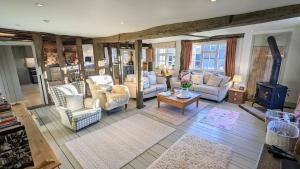 a living room with couches and chairs and a table at Grade 1 Listed Farm House 14 ppl 45 mins London in Fyfield