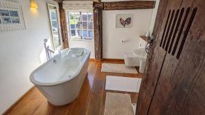 a bathroom with a large tub and a toilet at Grade 1 Listed Farm House 14 ppl 45 mins London in Fyfield +104 photos