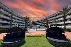 Un gran edificio con palmeras delante. en Palmera Beach, en Pilar de la Horadada