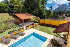 a backyard with a pool and chairs and a house at Casa Granja Comary - Teresópolis in Teresópolis