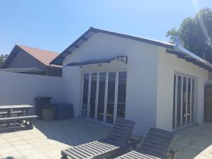 a patio with two chairs and an umbrella at Donsveertjie Gasteplaas & Venue in Heilbron