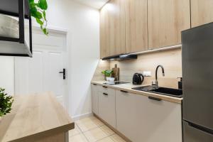 a kitchen with white cabinets and a sink at Old Town CityStay Rynek in Wrocław