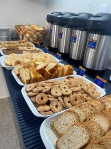 a table filled with different types of bread and pastries at Hotel Continental - Próximo ao Mercado Central, Mercado Novo e a Rodoviária in Belo Horizonte
