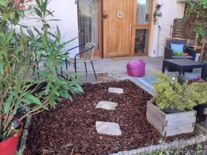 un jardin avec des rochers et des plantes devant une porte dans l'établissement Lac et montagnes en un clin d'oeil, à Duingt