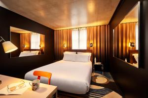 a hotel room with a bed and a table and a desk at Mama Shelter Paris East in Paris +127 photos