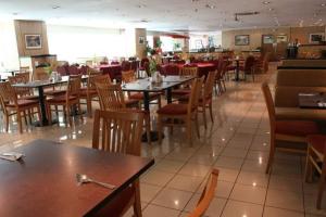 a dining room with tables and chairs and a restaurant at Richone Maluri Private Hotel in Kuala Lumpur
