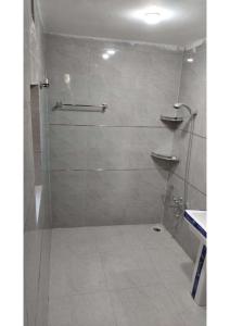a bathroom with a shower with a glass door at KHAATTZ CURATED STAYs in Shankarpur