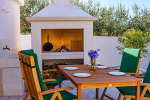 a patio with a table and a fireplace at Villa Mária Marta in Mirce