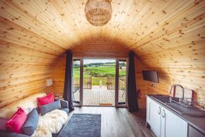 a living room with a couch in a wooden house at Secluded Countryside Cabins with bookable Sauna, Dark Skies & Stream Fell Farm Hideaway in Colwell