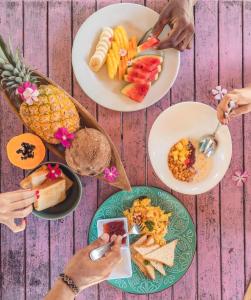 巴鲁岛AMALIFE Beach Club & Hotel的一群人在桌上盘子里吃食物