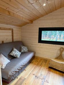 a couch in a room with a window at Petit paradis in Soustons