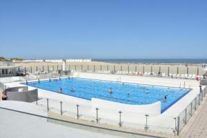 ein großer Pool mit Menschen in der Nähe des Strandes in der Unterkunft Studio 'Gauquié' in Oostduinkerke - Bad in Oostduinkerke