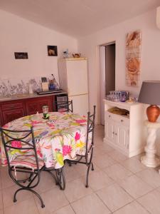 Una cocina con mesa y sillas y un refrigerador. en Métairie de l'église, en Sainte-Marthe