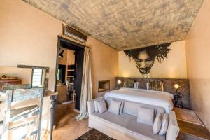 a bedroom with a large bed with a painting on the wall at The Source Hotel Music & Spa in Marrakesh