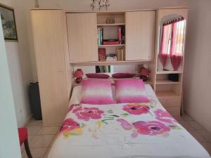 un dormitorio pequeño con una cama con flores rosas. en Métairie de l'église, en Sainte-Marthe
