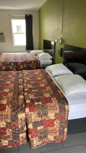 a row of beds in a hotel room at Fort Myers Inn in Fort Myers +16 photos