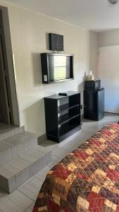 a hotel room with a bed and a flat screen tv at Fort Myers Inn in Fort Myers