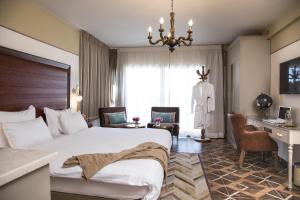 una camera d'albergo con un letto grande e una scrivania di Shtarkman Erna Boutique Hotel Nahariya a Nahariyya