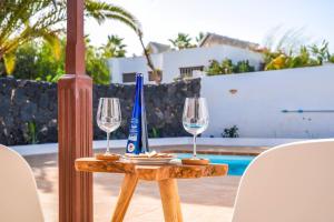 stół z dwoma kieliszkami wina na górze w obiekcie Agradable y familiar, con piscina "Casa Inima" w mieście Playa Blanca