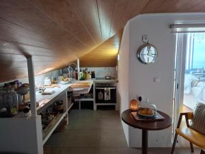a kitchen with a counter and a table in a room at Sally's Loft - Penthouse - Honeymoon suite in Ponta do Sol