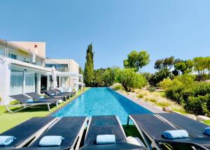 een zwembad met ligstoelen naast een huis bij CASA BRANCA ALGARVE infinity pool & shaded deck in Estói