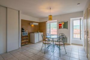 une cuisine avec une table et des chaises dans une pièce dans l'établissement La Bellevue en plein du coeur centre-ville avec wifi, à Millau 9 autres photos