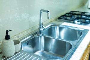 a stainless steel sink in a kitchen with a stove at Apt Matteucci 18 centro storico con parcheggio privato in Ravenna +20 photos
