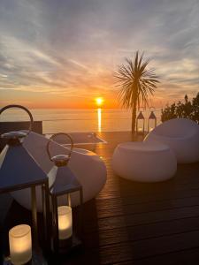 a sunset over the ocean with candles on a deck at Hotel Sporting Riccione in Riccione