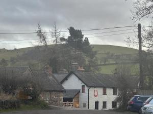 a white house with a hill in the background at The Bridges in Shrewsbury