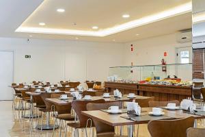 a dining room with tables and chairs and a cafeteria at Edifício Curitiba João Bettega in Curitiba