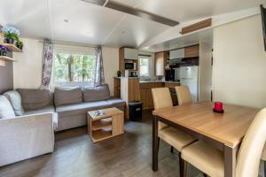 a living room with a couch and a table at Mobil home 8 personnes in Saint-Brevin-les-Pins