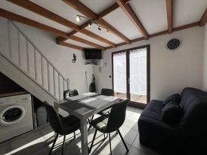 a living room with a table and a couch at Villa T3 avec terrasse, 6 couchages, proche plage et commerces, quartier calme, parking privé - FR-1-81-365 in Port Leucate