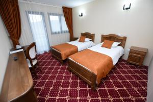 a hotel room with two beds and a television at Condor Resort in Dulceşti +18 photos