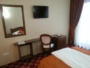 ein Hotelzimmer mit Bett, Schreibtisch und Spiegel in der Unterkunft Condor Resort in Dulceşti